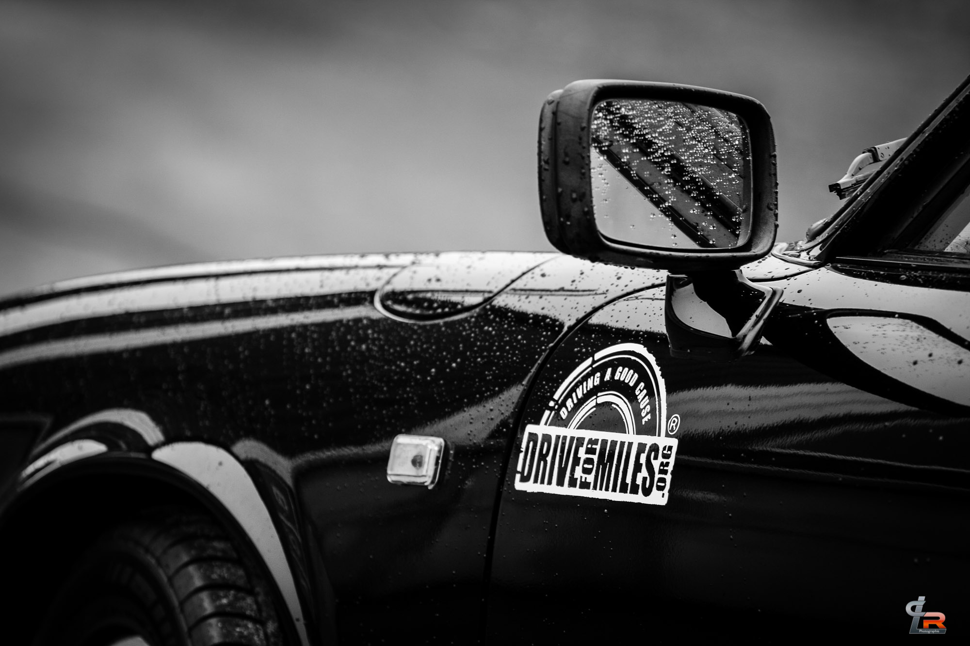 Drive for Miles badge on a black car door (black and white)