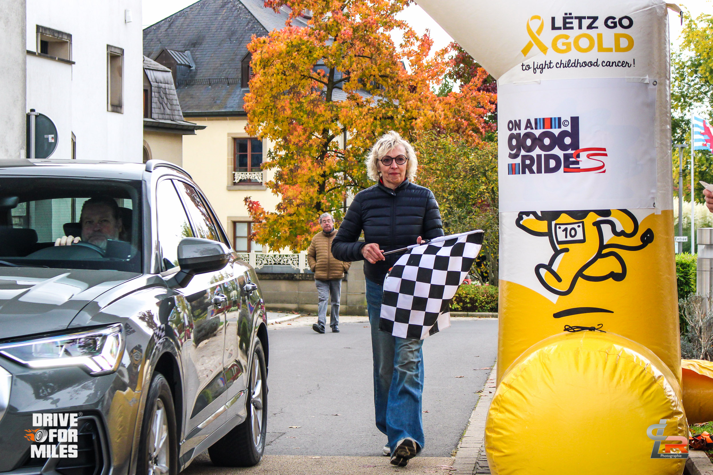 A man with a chequered flag at the Good Ride finish line